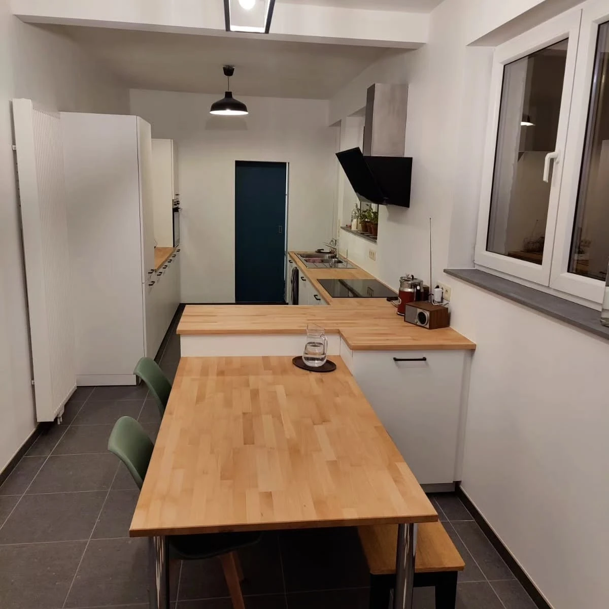 Cuisine rénovée, avec mobilier blanc et plans de travail en bois